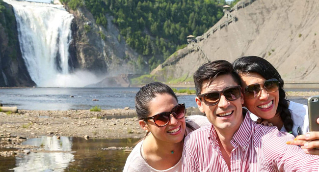 Bildungsurlaub Québec Kanada mit LISA! – Französisch lernen und Naturerlebnisse geniessen Erwachsene machen Selfie vor Wasserfall in Québec während eines LISA! Bildungsurlaubs erleben Natur und internationale Freizeitaktivitäten