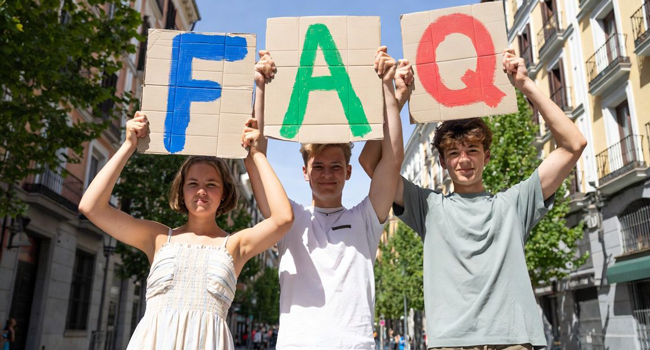 Teilnehmer mit FAQ-Schildern während eines Spanisch-Sprachaufenthalts für Young Adults in Madrid