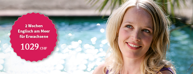 Blonde Frau steht lächelnd vor einem glitzernden Pool bei einem Sprachaufenthalt Englisch