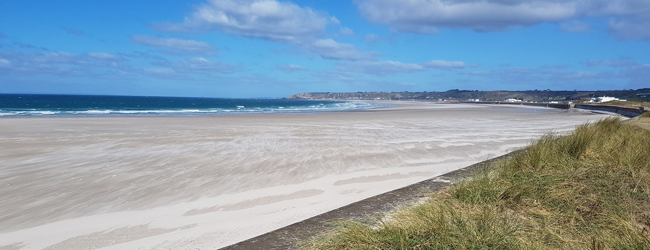 Breiter weisser Sandstrand an der Insel Jersey in England im Sommer